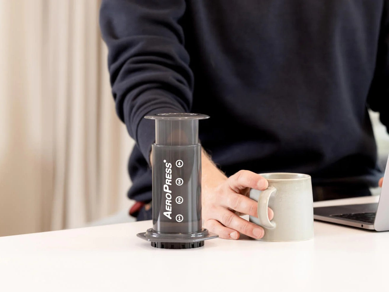 Aeropress press with man drinking coffee