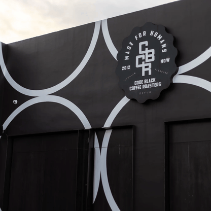 Black coffee roaster sign with white text on a black background