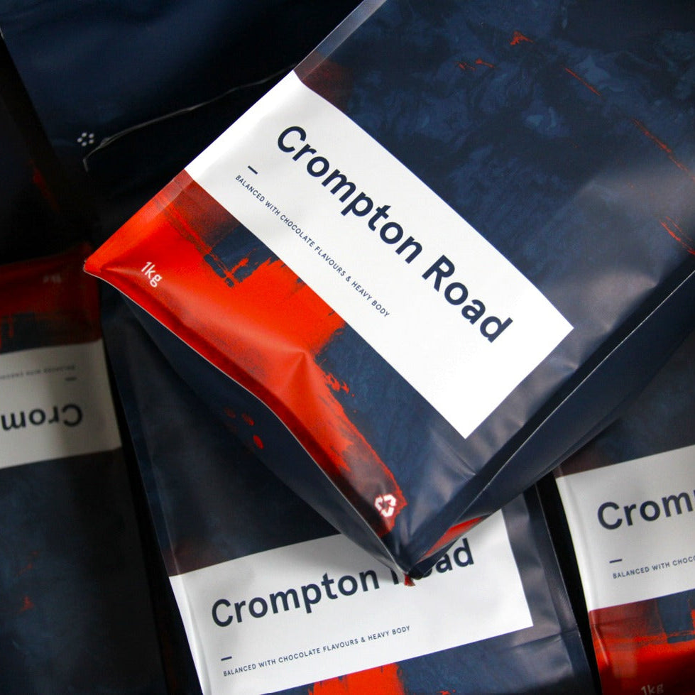 Crompton Road coffee packages with visible branding on a dark background