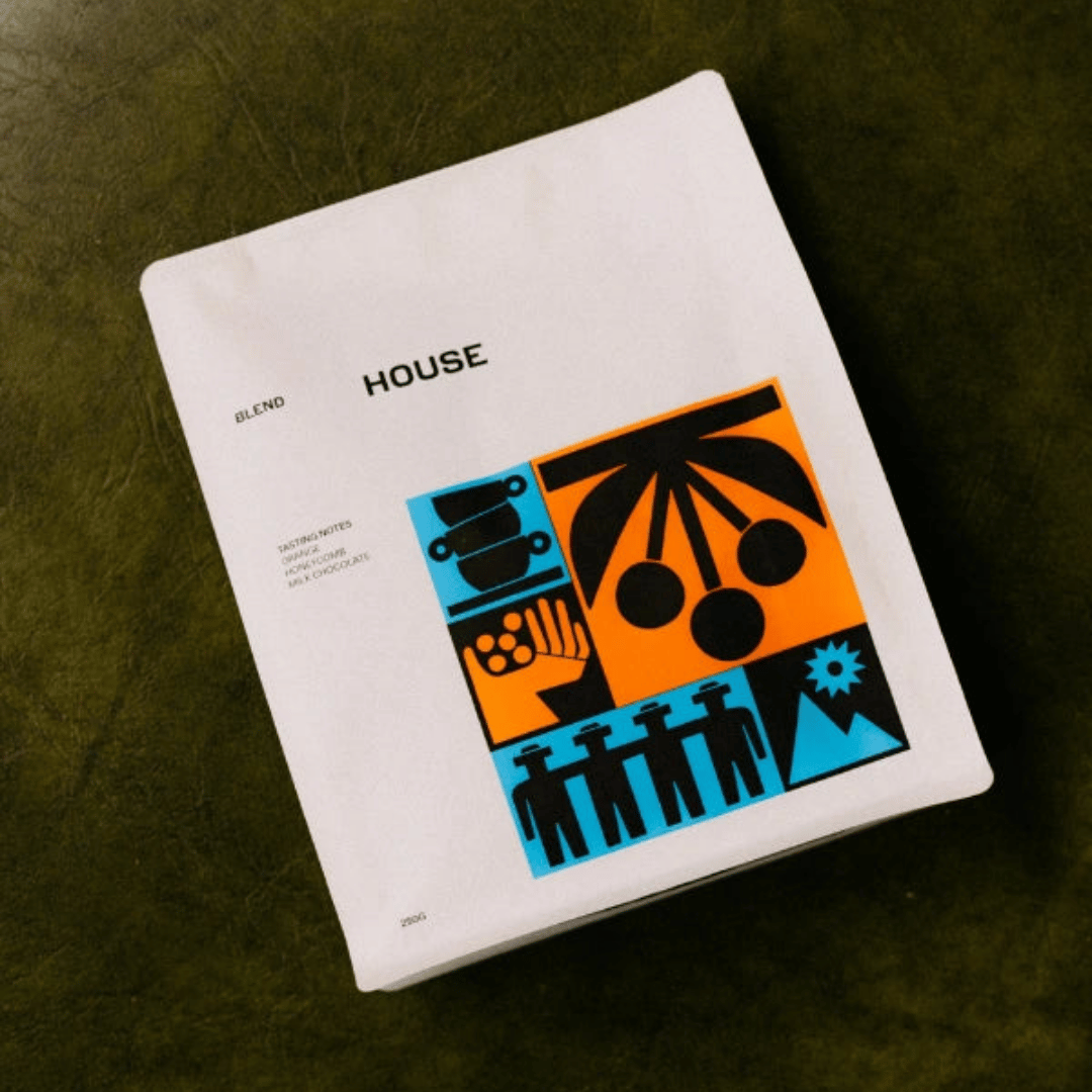 Coffee package with 'HOUSE' branding and colorful design on a dark surface