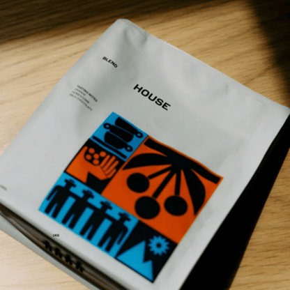 Two Moka coffee bags with colorful designs on a wooden shelf.