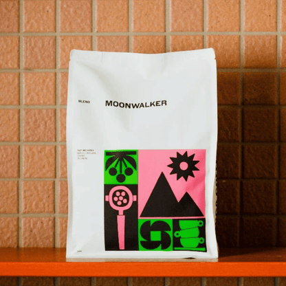 White coffee bag with colorful graphics and 'MOONWALKER' branding on a tiled wall background